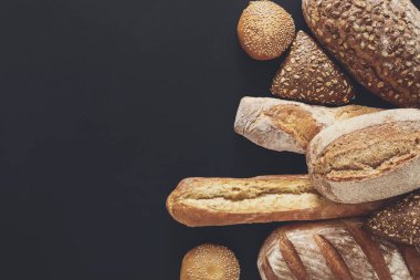 Fırın arka plan, siyah izole ekmek ürün yelpazesine sahip. Kopya alanı ile Üstten Görünüm