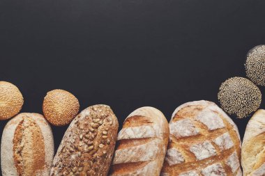 Fırın arka plan, siyah izole ekmek ürün yelpazesine sahip. Kopya alanı ile Üstten Görünüm