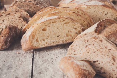 Ekmek arka plan. Beyaz ve çavdar, ahşap masa üzerinde tüm ve dilimlenmiş somun closeup ile un, kopya alanı serpilir