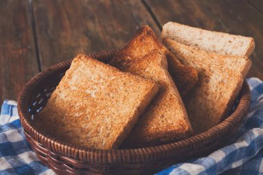 Hasır breadbasket damalı tablo peçete yarım kaplama ahşap masa, closeup Tarih içinde kahvaltı arka plan, beyaz ekmek tost