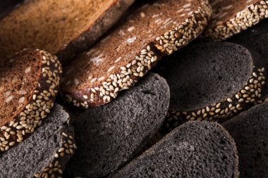 Siyah ekmek degrade arka plan dilimlenmiş. Ekmek pasta ve bakkal kavramı. Çavdar ve beyaz somun türlü ahşap üzerine dilimlenmiş taze, sağlıklı bütün tahıl