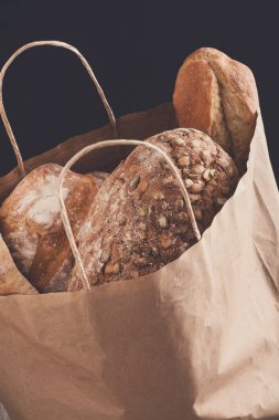 Kağıt torba siyah arka plan, ekmek ürün yelpazesine sahip. Pastanede alışveriş