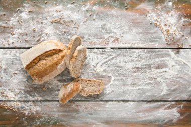 Fırın ve market geçmişi. Dilimlenmiş buğday ekmeği ahşap masaya serpilmiş un serpiştirilmiş, üst görünüm, hamur işi için makara yap, boşluk kopyala