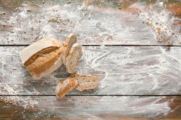 Fırın ve market geçmişi. Dilimlenmiş buğday ekmeği ahşap masaya serpilmiş un serpiştirilmiş, üst görünüm, hamur işi için makara yap, boşluk kopyala