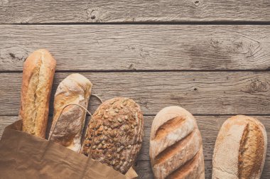 Ekmek, ekmek rustik ahşap arka plan, bakkal kavramı üzerinde kağıt torba içinde.