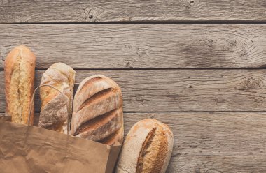 Ekmek, ekmek rustik ahşap arka plan, bakkal kavramı üzerinde kağıt torba içinde.