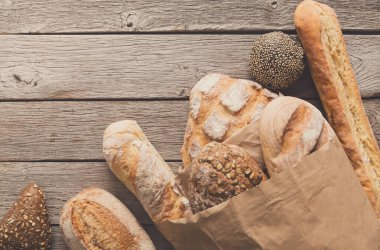 Ekmek, ekmek rustik ahşap arka plan, bakkal kavramı üzerinde kağıt torba içinde.