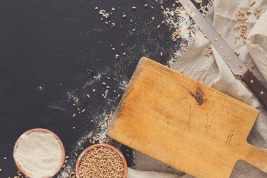 Arka plan, un ve kesme tahtası siyah, pişirme. Ekmek pasta ve evde ekmek yapma kavramı. Kopya alanı