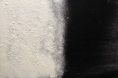 Bu sanat eseri düz bir yüzey üzerindeki dokuların ve renklerin dinamik etkileşimini gösteren ince beyaz un ve koyu kömür tozu arasında katıksız bir tezat içerir..