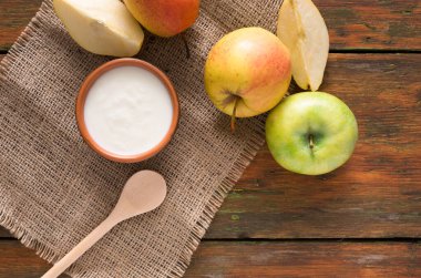 Kahvaltıda ev yapımı doğal çiftçi yoğurt kavanoza taze meyve - armut ve elma ahşap masa, üstten görünüm