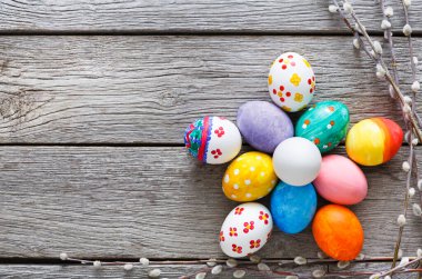 El yapımı ahşap arka plan üzerinde Paskalya yumurta boyalı. Rustik tablo kopya alanı üst görünümle renkli tatil dekorasyon