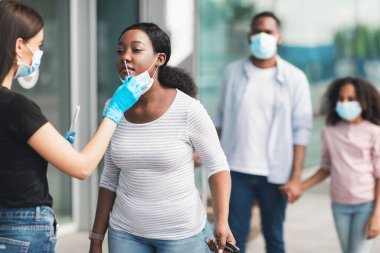 Coronavirus Teşhis ve Deneme. Vardıktan sonra havaalanında duran steril çubuk çubuğu kullanan siyah kadın turist için burun röntgeni 19 PCR testi yapan bir tıp işçisi. Covid Antijen Sınavı