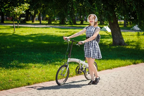 Young woman rides bicycle in the park — Stock Photo, Image