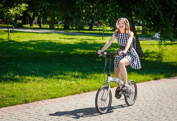 Young woman rides bicycle in the park — Stock Photo, Image