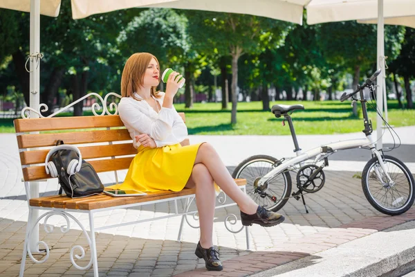 Mujer joven bebe café en el parque — Foto de Stock