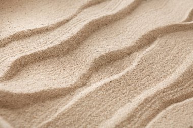 Kumsal dalgalı kum arka planı. Doğal deniz kıyısı dokusu yüzeyi, yakın çekim.