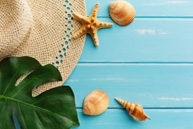 Mavi ahşap üzerinde tatil arka planı, fotokopi alanı olan üst manzara. Hasır şapka ve deniz kabukları