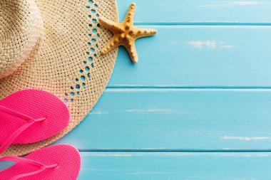 Tatil arka plan mavi ahşap, en iyi kopya alanı görünümle. Plaj çakıl, flip flop, deniz kıyısı ve hasır şapka