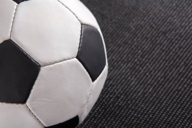 Siyah ve beyaz panelleri olan bir futbol topu koyu renkli bir yüzeye oturur. Ayarlar spor aktiviteleri için bir yer öneriyor. Sahne top tasarımı ve materyalleri vurguluyor..