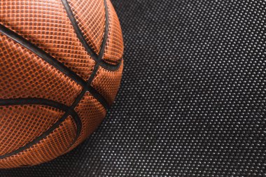 Bir basketbol topu karanlık bir yüzeye yerleştirilir. Yüzeyin desenli bir şablonu var. Bu da olay yerine detay katıyor. Bu resim herhangi bir oyuncu olmadan topların yüzeyine ve tasarımına odaklanır.