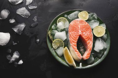 Limon ve limon dilimleriyle buz yatağına yerleştirilmiş somon fileto parçaları. Kurulum yemek ya da servis için hazır. Olay yeri basit ve düzenli..