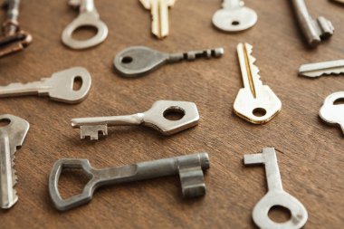 Anahtarlar ahşap bir masanın üzerine konur. Anahtarlar farklı şekil ve boyutlarda geliyor. Bu koleksiyon bir metal nesne mozaiği oluşturuyor. Hepsi gelişigüzel düzenlenmiş..