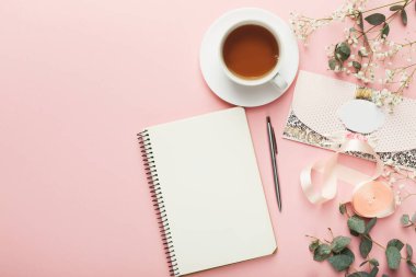 Pembe bir yüzeye bir nesne koleksiyonu yerleştirilir. Bir fincan çay boş bir defter ve bir kalemin yanında oturur. Yakınlarda çiçekler ve kurdeleler var. Bu sahne bir yaratıcılık anını temsil ediyor..