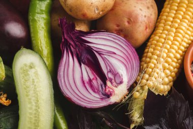 Bir kolaj çeşitli taze sebzeleri gösterir. Sergide salatalık, patates, mısır, biber ve soğan yer alıyor. Düzenleme her sebzenin farklı şekil ve renklerini vurgular.