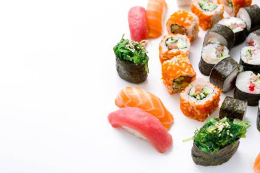 Çeşitli suşi türleri beyaz bir yüzey üzerinde dairesel bir tasarıma yerleştirilir. Somon, ton balığı ve sebze dürümleri renkli suşilerle aynı mekanı paylaşırlar. Bu ekran paylaşıma hazır.