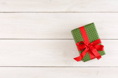 Tahta bir yüzeyde paketlenmiş bir hediye koleksiyonu duruyor. Hediyeler renkli kağıt ve kurdelelerle süslenmiş. Bu sahne tatil hazırlıklarının ve kutlamaların heyecanını yakalıyor..