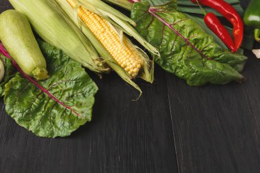 Taze sebzelerden oluşan bir kolaj koyu ahşap bir masanın üzerine serilmiştir. Düzenlemede mısır, yapraklı yeşiller ve renkli biberler yer alıyor. Bu koleksiyonda çeşitli organik ürünler sergileniyor.
