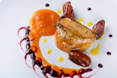 Bir parça domuz pişirilir ve tabağın ortasına yerleştirilir. Tabak sos, hurma ve renkli bir püre ile süslenmiş. Bu yemeğin yaratıcı bir sunumu..