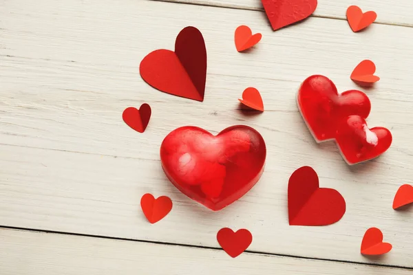 Kırmızı kalp şekilleri açık ahşap bir yüzeye saçılmıştır. Koleksiyonda çeşitli malzemelerden yapılmış daha büyük ve daha küçük kalpler yer alıyor. Bu kurulum kutlamalar için uygundur..