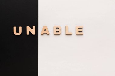 Kelimenin hecelenmesini sağlayan tahta harfler siyah ve beyaz bir arkaplanda oturamaz. Bu düzen basit elementlerle güçlü bir görsel karşıtlık yaratır. Odak noktası mektuplar..