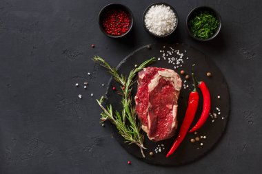 Bir parça çiğ et siyah taştan bir yüzeye yerleştirilir. Kırmızı biber, biberiye ve tuzlu, biberli ve otlu kaseler eti çevreleyerek yemek hazırlığı için bir sahne yaratıyor..