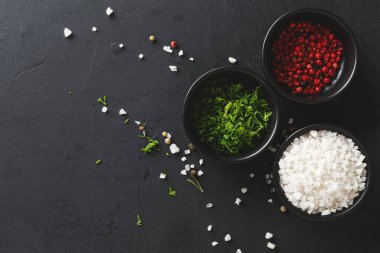 Karanlık bir yüzeye üç kase yerleştirilir. Bir kasede tuz, diğerinde kırmızı biber var. Üçüncüsünde ise yemek pişirmek için basit bir düzen..