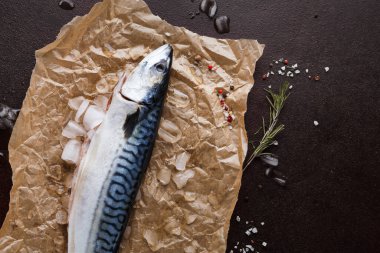 Bütün bir uskumru kahverengi kağıda buz ve çeşitli baharatlarla yerleştirilir. Bu düzenek yemek hazırlığı için hazır bir mutfak alanını gösteriyor. Balık taze ve temiz..