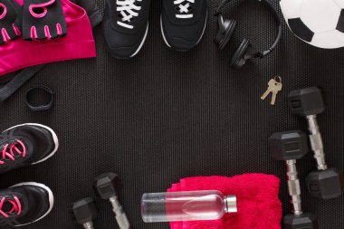 Jimnastik paspasının üzerine bir spor malzemesi koleksiyonu yerleştirilir. Siyah spor ayakkabılar, dambıllar, kulaklıklar, bir futbol topu ve bir su şişesi mevcut. Bir havlu ve anahtarlar da dahil..