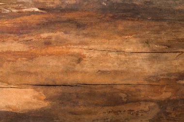 Yakın çekim, doğal çizgiler ve renk değişimleriyle ahşap bir yüzey gösteriyor. Işık yüzeyden yansıyarak dokusunu ve özelliklerini vurgular. Bu sahne odunun özünü yakalar..