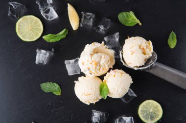 Dondurma kalıpları taze nane ve limon dilimleriyle buz yatağında oturur. Sahne serinletici bir şey gösteriyor sıcak hava için mükemmel. Parlak turunçgiller yapılandırmaya tat katar.