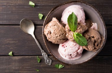 İki kepçe çikolatalı dondurma, bir kepçe çilekli dondurma ve bir kepçe vanilyalı dondurma bir kasede servis edilir. Taze nane yaprakları tepeyi süslüyor. Kasenin yanına metal bir kaşık konur..