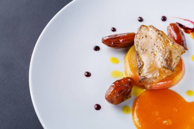 Beyaz bir tabakta bir parça et, portakal dilimleri ve sos ile servis edilir. Yemeklerin etrafına tarihler dizilir. Restoranda renkli ve ilginç bir sunum yapılır..