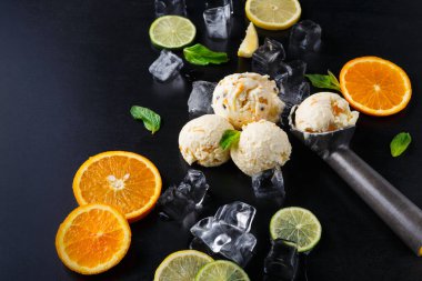 Dondurma kalıpları, portakal dilimleri ve limon dilimleriyle buz yatağında dinleniyor. Taze nane yaprakları kuruluma biraz renk katar. Ayarlar asgari ve odaklı..