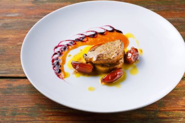 Tabakta pişmiş et, renkli soslar ve sanatsal olarak yerleştirilmiş süsler yer alıyor. Akşam yemeği ya da öğle yemeği saatinde bir restoran öneriliyor..