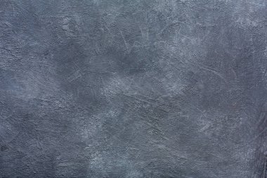 Gri bir duvar çeşitli doku ve desenleri gösterir. Yüzey, ince renk değişiklikleriyle dengesiz görünüyor. Işık duvara çarpıyor ve özelliklerini vurguluyor. Bu ayar birçok amaca hizmet edebilir..