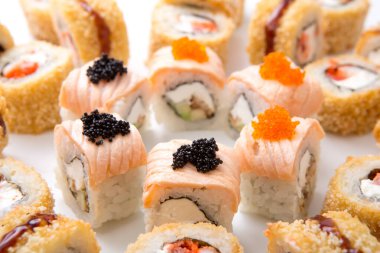 Tabaklar bir restoranda somon, yengeç ve havyarla dolu çeşitli suşi rulolarıyla dolu. Bu yemek, yemek sırasında servis edilir. Restoranları çeken renkler ve dokular sergilenir..