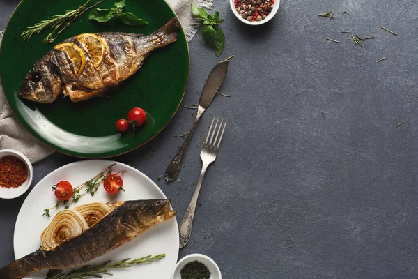 Izgara balık yeşil bir tabağa konur. Limon dilimleri ve otlarla birlikte. İkinci bir balık, sarmal makarna ve kiraz domatesleriyle birlikte beyaz bir tabakta. Etrafta bir kase baharat var..