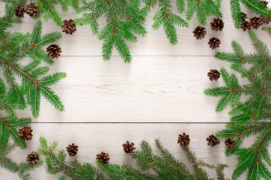 Çam dalları ve çam kozalakları hafif ahşap bir yüzeyde kolaj olarak düzenlenir. Yapraklar doğal bir sınır oluşturur, mevsimsel elementler tipik kışa benzer..