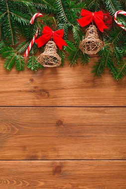 Kolajda tahtadan bir yüzeye yerleştirilmiş küçük çanlar, kırmızı kurdeleler ve şeker kamışları gibi Noel temalı eşyalar yer alıyor. Sahne, tatil sezonunun ruhunu yansıtıyor..