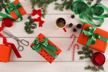 Hediyeler kırmızı ve yeşil kağıda sarılır ve beyaz ahşap bir masaya dizilir. Makas, kurdele, şeker kamışı ve kahve hediyelerin etrafını sarar..